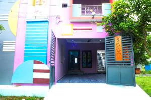 een roze huis met een kleurrijke voordeur bij Nandhi home stay in Tiruvannamalai