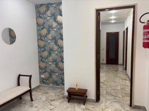 a hallway with a mirror and a chair and a table at Acqua Holiday House in Taranto