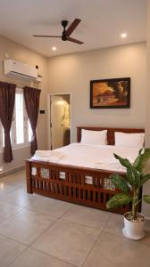 une chambre avec un grand lit avec un ventilateur de plafond dans l'établissement Dwaraka Resorts, à Tiruvannāmalai