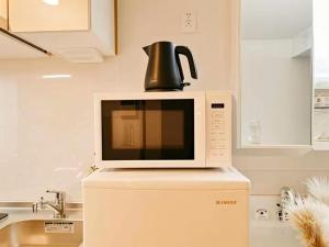 a microwave with a tea kettle on top of it at Minami Ikebukuro APT Dear Cosmo Ikebukuro subway 6mins in Tokyo +91 photos