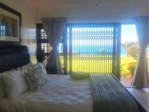 a bedroom with a bed and a large window at Kuta Beach 7 in Margate +16 photos
