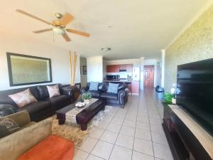 a living room with a couch and a flat screen tv at Kuta Beach 7 in Margate