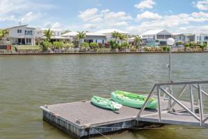 un muelle con dos barcos en el agua en Spacious waterfront home with pontoon, pool, BBQ, en Kawana Waters