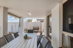 Un comedor con mesa y sillas de madera. en Spacious waterfront home with pontoon, pool, BBQ, en Kawana Waters 27 fotos más