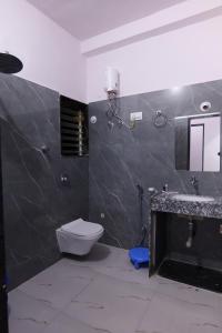 a bathroom with a toilet and a sink and a mirror at Hotel Majestic Royal, Akkalkot in Akalkot
