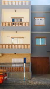 un edificio con un cartello blu davanti di GoBeyond - Serra T2 a Porto Novo