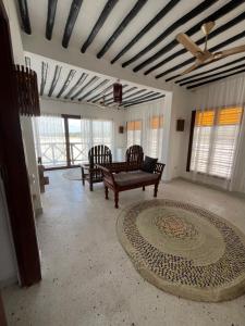 a living room with a ceiling fan and a couch at Malcom Ocean View Retreat in Pongwe