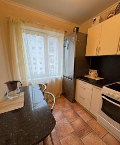 una cocina con una mesa y un refrigerador en Rahu 2838 Apartment, en Narva