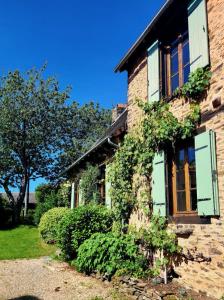a brick house with green shutters on it at Birdsong in Saint-Éloy-les-Tuileries