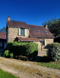 a brick house with a brown roof and some bushes at Birdsong in Saint-Éloy-les-Tuileries