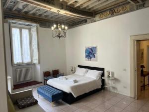 a bedroom with a bed and a chandelier at Il Carapace - Appartamento nel cuore di Foligno in Foligno