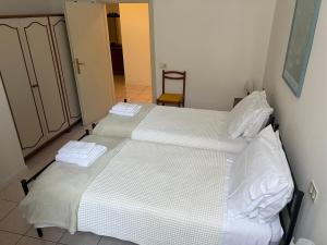 a bedroom with two beds with white sheets at Il Carapace - Appartamento nel cuore di Foligno in Foligno