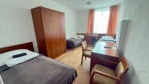 a room with two beds and a desk and a table at KING Guest Inn in Drawsko Pomorskie