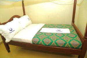 a bed with two pillows on top of it at ndugu gardens kasese guest house in Kasese
