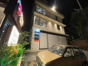 a car parked in front of a house at night at The Marina Deluxe Kozhikode - Premium Spacious AC Rooms in Kozhikode