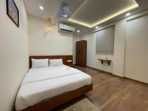 a bedroom with a large white bed and a window at The Marina Deluxe Kozhikode - Premium Spacious AC Rooms in Kozhikode