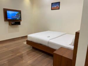 a bedroom with a bed and a flat screen tv at The Marina Deluxe Kozhikode - Premium Spacious AC Rooms in Kozhikode +12 photos