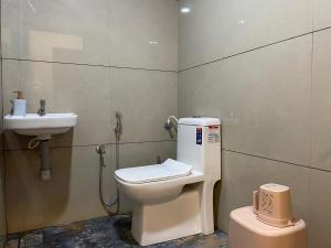 a bathroom with a toilet and a sink at The Marina Deluxe Kozhikode - Premium Spacious AC Rooms in Kozhikode