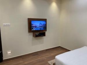 a tv on a white wall in a room at The Marina Deluxe Kozhikode - Premium Spacious AC Rooms in Kozhikode