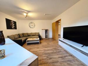 a living room with a couch and a flat screen tv at Moritz Apartments - Am Rieseninger Berg 1 in Görmar