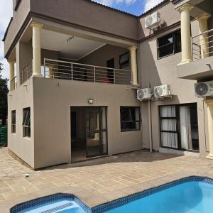 a house with a swimming pool in front of it at Divine Boutique Hotel in Rustenburg