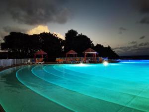 - une grande piscine avec des lumières bleues la nuit dans l'établissement Villa 852 Taycan Anse des Rochers, Guadeloupe, à Îlet à Christophe