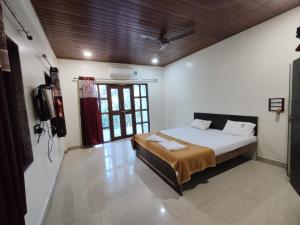 een slaapkamer met een bed en een tv erin bij Konkan Paradise-Siddhivinayak,Devbag Beach Resort in Malvan +100 foto's