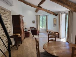 a living room with a wooden table and chairs at Gite l'olivier des maraichers in Albigny-sur-Saone