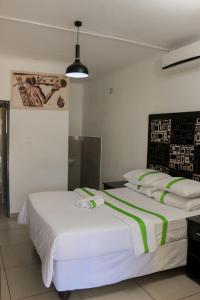 a bedroom with two beds with green and white sheets at Silk Mbare Guest House in Manzini