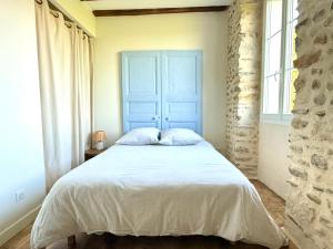莫南Maison Ganibette, corps de ferme rénové的卧室里有一张带蓝色床头板的床