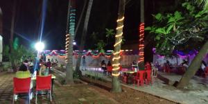 a group of tables and chairs with christmas lights at Konkan Paradise,Devbag Sangam Beach Resort in Malvan