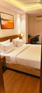 a bedroom with a large bed with white pillows at Silvotel Premier By Bizzgrow Hotels in Indore
