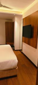 a bedroom with a bed and a flat screen tv at Silvotel Premier By Bizzgrow Hotels in Indore