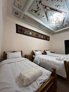 a room with three beds and a stained glass ceiling at Shahina in Samarkand