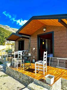 a wooden deck with a table and chairs on it at Tony Home in Borsh