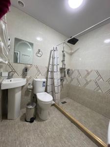 a bathroom with a toilet and a sink and a shower at Shahina in Samarkand