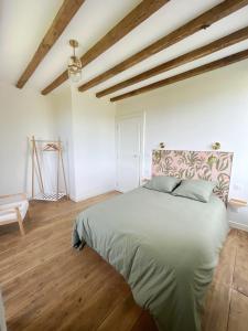 莫南Maison Ganibette, corps de ferme rénové的铺有木地板的客房设有一间带大床的卧室