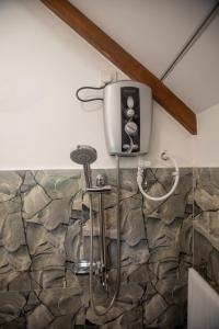 een tv aan de muur in een badkamer bij Middle of The Village Sigiriya in Palutawa