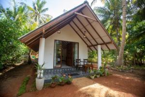 een klein huis met een veranda en een aantal planten bij Middle of The Village Sigiriya in Palutawa +11 foto's