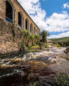 an old brick building next to a river at Casa LV 2 in Lençóis +21 photos
