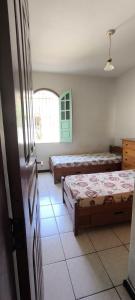 a bedroom with two beds and a window at Casa LV 2 in Lençóis