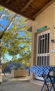 a porch with a blue and white table in front of a door at Olive Grove Cottage Guest house in Kouka