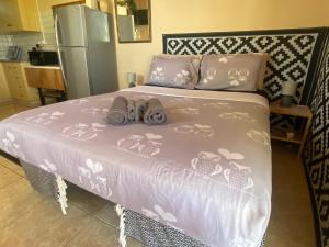 a pink bed with towels on it in a kitchen at Olive Grove Cottage Guest house in Kouka