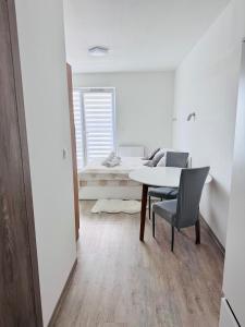 a white room with a table and chairs and a bed at Perła Mórz 74 in Sianozety