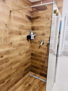a bathroom with a shower with wooden walls at Perła Mórz 74 in Sianozety