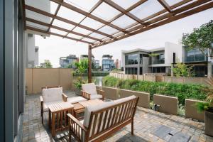 a patio with benches and a table and chairs at TRON Villa - Regal Victoria Luxury BT9-09 in Dien Ban