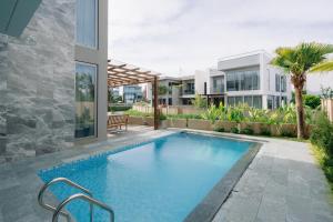 a swimming pool in the backyard of a house at TRON Villa - Regal Victoria Luxury BT9-09 in Dien Ban