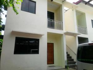 a white building with a door and stairs in front at Carolina Siargao Homestay in General Luna