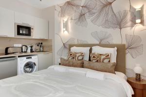 a bedroom with a large bed and a kitchen at Charmant et central - Neuilly in Neuilly-sur-Seine