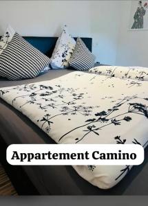 Cama con sábanas y almohadas blancas y negras en Maxhof Trier, en Trier
